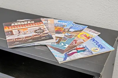 a pile of magazines sitting on top of a table at Iola in Aurora