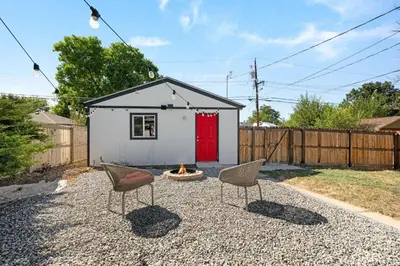 a tiny house with a red door and two chairs at Iola in Aurora