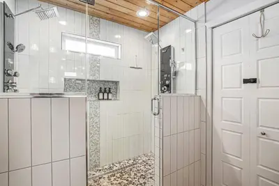 a bathroom with a shower with a glass door at Backyard Wonderland Ultimate Outdoor Fun in Denver