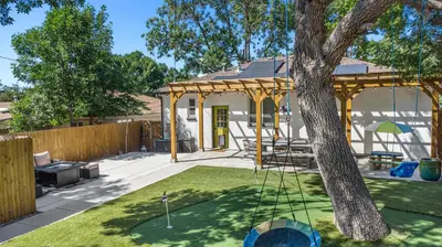 a yard with a tree with a swing at Backyard Wonderland Ultimate Outdoor Fun in Denver