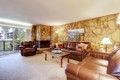 a living room with leather furniture and a stone wall at A105 Lake Cliffe condo in Dillon