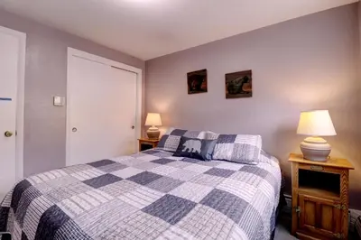 a bedroom with a blue and white bed and two lamps at Yacht Club 27 condo in Dillon