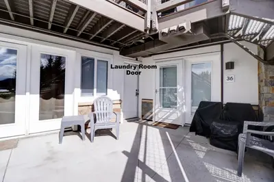 a porch with two chairs and a laundry room door at Yacht Club 27 condo in Dillon