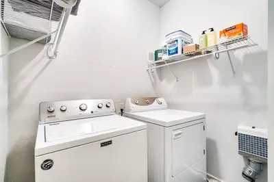 a small white kitchen with a washer and dryer at Updated 2 Bedroom home near Downtown! in Denver