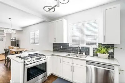 a white kitchen with a stove and a sink at Updated 2 Bedroom home near Downtown! in Denver