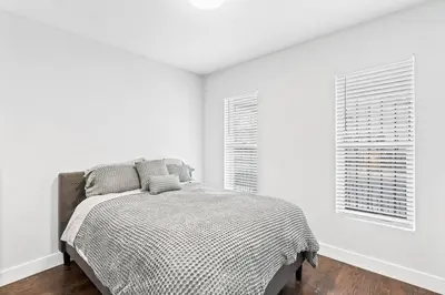 a white bedroom with a bed and two windows at Updated 2 Bedroom home near Downtown! in Denver