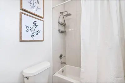 a white bathroom with a toilet and a shower at Updated 2 Bedroom home near Downtown! in Denver