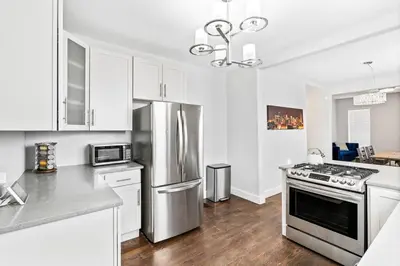 a kitchen with white cabinets and a stainless steel refrigerator at Updated 2 Bedroom home near Downtown! in Denver