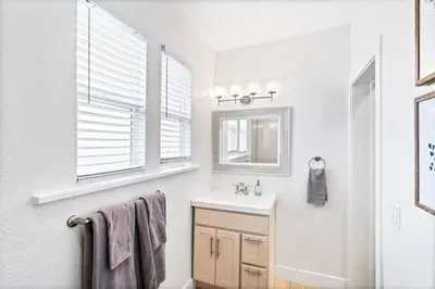 a white bathroom with a sink and a mirror at Updated 2 Bedroom home near Downtown! in Denver