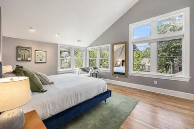 a bedroom with a large bed and windows at Secret Garden Retreat in Park Hill in Denver
