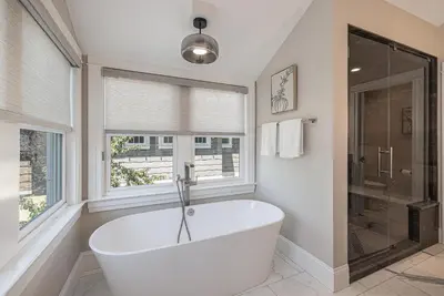 a white bath tub in a bathroom with windows at Secret Garden Retreat in Park Hill in Denver