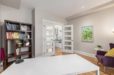 a living room with a white table and bookshelves at Secret Garden Retreat in Park Hill in Denver