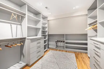 a walk in closet with white cabinets and a rug at Secret Garden Retreat in Park Hill in Denver
