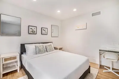 a white bedroom with a bed and a desk at Townhouse near Cherry Creek w gym in Denver