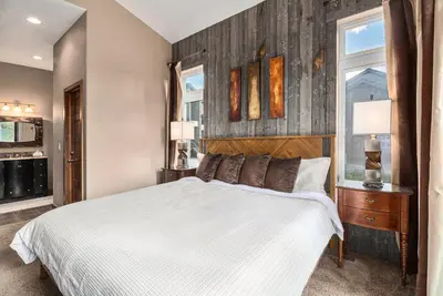 a bedroom with a white bed and a window at Fraser retreat w balcony , fireplace & BBQ in Fraser