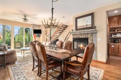 a dining room with a table and a fireplace at Fraser retreat w balcony , fireplace & BBQ in Fraser