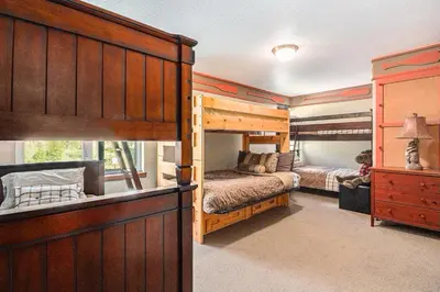 a bedroom with two bunk beds and a large window at Fraser retreat w balcony , fireplace & BBQ in Fraser