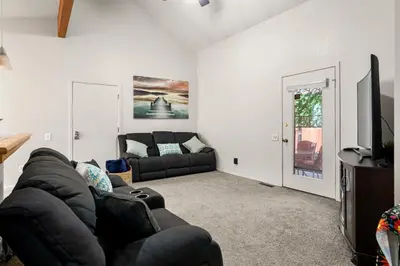 a living room with a black couch and a flat screen tv at A Denver Oasis 15 Min to the Bronco Stadium 3 Bedroom with a King Suite in Denver