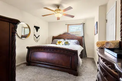 a bedroom with a wooden bed and a ceiling fan at A Denver Oasis 15 Min to the Bronco Stadium 3 Bedroom with a King Suite in Denver