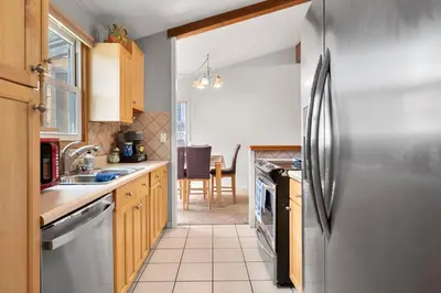 a kitchen with a stainless steel refrigerator and a table at A Denver Oasis 15 Min to the Bronco Stadium 3 Bedroom with a King Suite in Denver