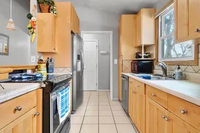 a kitchen with wooden cabinets and a stainless steel refrigerator at A Denver Oasis 15 Min to the Bronco Stadium 3 Bedroom with a King Suite in Denver