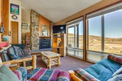 a living room with a couch and a table at Walk to Ski Lift and Hiking Granby Ranch Condo! in Granby