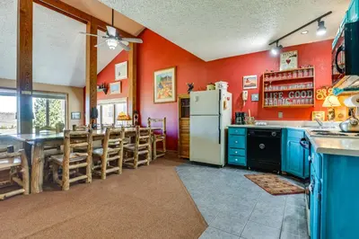 a kitchen with a refrigerator and a table and chairs at Walk to Ski Lift and Hiking Granby Ranch Condo! in Granby