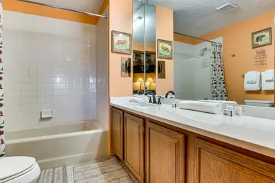 a bathroom with a tub and a sink and a toilet at Walk to Ski Lift and Hiking Granby Ranch Condo! in Granby