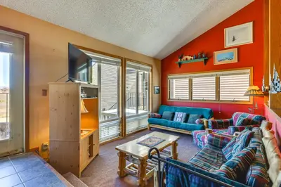 a living room with a couch and a tv at Walk to Ski Lift and Hiking Granby Ranch Condo! in Granby