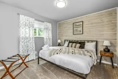a bedroom with a bed and a wooden wall at Modern Family Haven Fenced Yrd GrillFirepit in Westminster