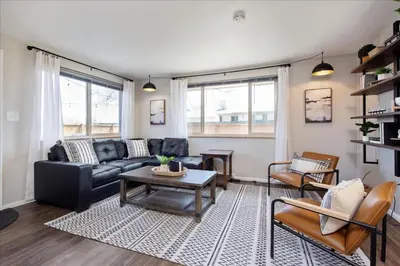 a living room with a couch and a table at Modern Chic Retreat Near Mtns & Red Rocks Wifi in Wheat Ridge