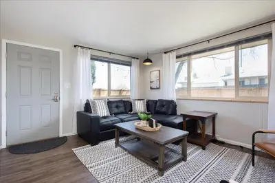 a living room with a couch and a table at Modern Chic Retreat Near Mtns & Red Rocks Wifi in Wheat Ridge