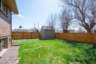 a backyard with a fence and green grass at Modern Chic Retreat Near Mtns & Red Rocks Wifi in Wheat Ridge