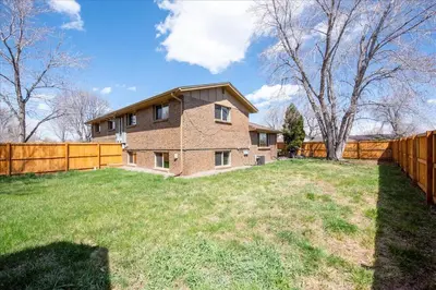 a house with a fence in a yard at Modern Chic Retreat Near Mtns & Red Rocks Wifi in Wheat Ridge