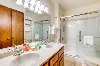 a white bathroom with a sink and a shower at 2 Mi to Granby Ranch Studio with Resort Amenities! in Granby