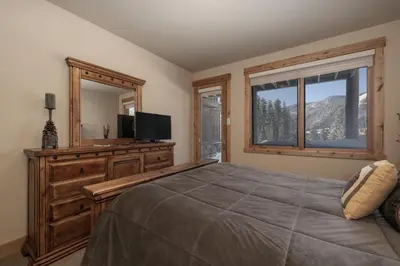 a bedroom with a bed and a television and a window at Antler at Lakota 407 home in Winter Park