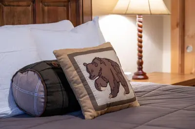 a bear pillow on a bed next to a lamp at Antler at Lakota 407 home in Winter Park