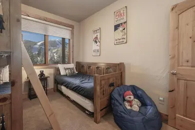 a bedroom with a bed with a teddy bear in a chair at Antler at Lakota 407 home in Winter Park