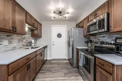 a kitchen with wooden cabinets and stainless steel appliances at Colorado home near Red Rocks w fenced yard in Wheat Ridge