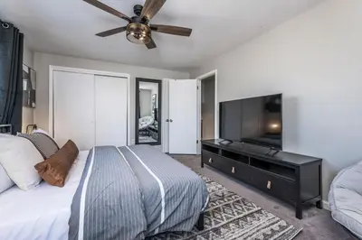 a bedroom with a bed and a flat screen tv at Colorado home near Red Rocks w fenced yard in Wheat Ridge