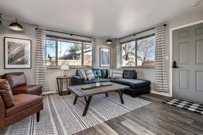 a living room with a couch and a table at Colorado home near Red Rocks w fenced yard in Wheat Ridge