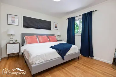 a bedroom with a bed with orange and blue pillows at Peaceful home w fire pit & game room in Denver