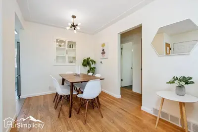 a dining room with a table and white chairs at Peaceful home w fire pit & game room in Denver