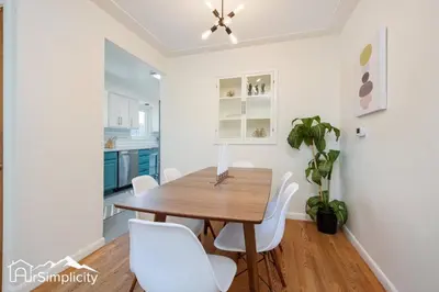 a dining room with a wooden table and white chairs at Peaceful home w fire pit & game room in Denver