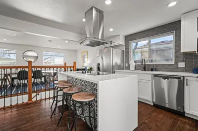 a kitchen with a counter with stools and a bar at The Denver Den Game Room Foosball in Westminster