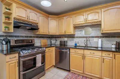 a kitchen with wooden cabinets and stainless steel appliances at Spacious home w hot tub & fire pit in Denver