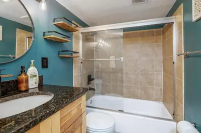 a bathroom with a tub and a toilet and a sink at Spacious home w hot tub & fire pit in Denver