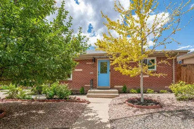 a brick house with a blue door and a tree at Spacious home w hot tub & fire pit in Denver