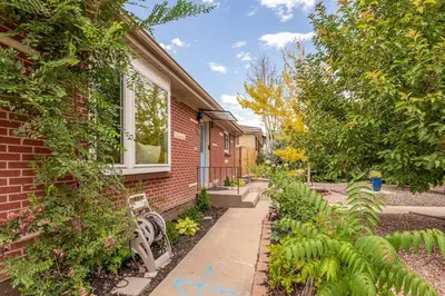a brick house with a bench in a garden at Spacious home w hot tub & fire pit in Denver