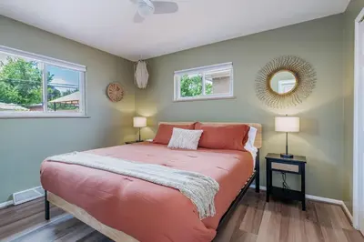 a bedroom with a bed and two windows at Spacious home w hot tub & fire pit in Denver